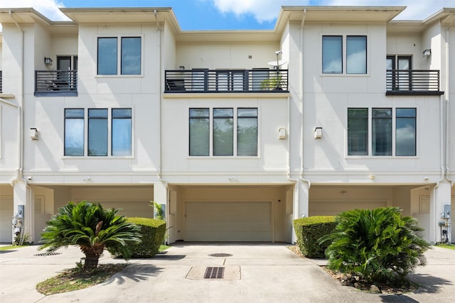 3909 Rose St, Houston, TX 77007 - view of front facade featuring stucco siding, an attached garage, and driveway