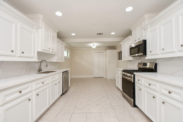 44 Farrell St, Houston, TX 77022 - kitchen with appliances with stainless steel finishes, a sink, backsplash, white cabinetry, and ornamental molding