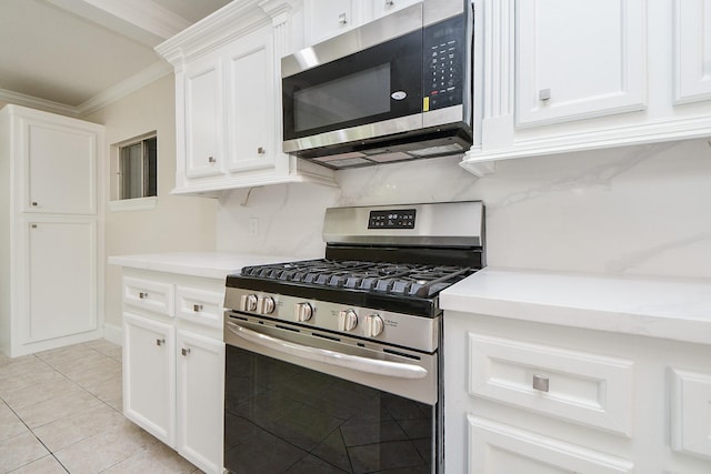 44 Farrell St, Houston, TX 77022 - kitchen with appliances with stainless steel finishes, ornamental molding, light countertops, white cabinetry, and light tile patterned floors