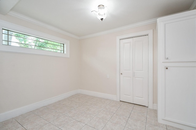44 Farrell St, Houston, TX 77022 - unfurnished bedroom with crown molding, a closet, baseboards, and light tile patterned flooring