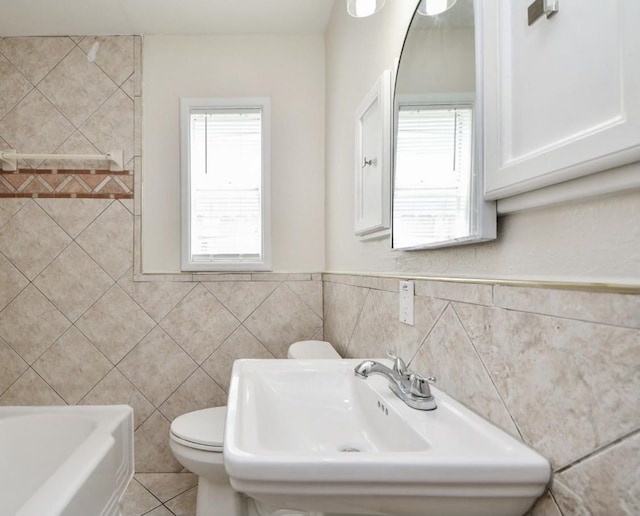 44 Farrell St, Houston, TX 77022 - full bath featuring tile walls, a sink, plenty of natural light, toilet, and a bath