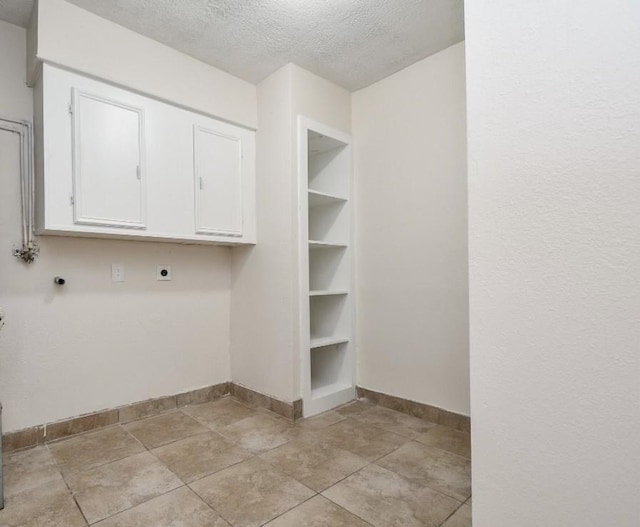 44 Farrell St, Houston, TX 77022 - laundry area with electric dryer hookup, baseboards, a textured ceiling, and cabinet space