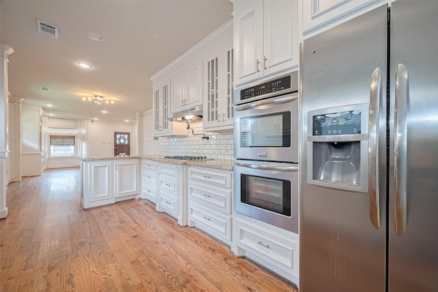 901 W 21st St, Houston, TX 77008 - kitchen featuring stainless steel appliances, tasteful backsplash, white cabinetry, light stone counters, and recessed lighting