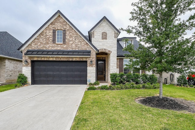 2234 Clements Shore Ln, La Porte, TX 77571 - french country home featuring concrete driveway, stone siding, a front yard, and a garage