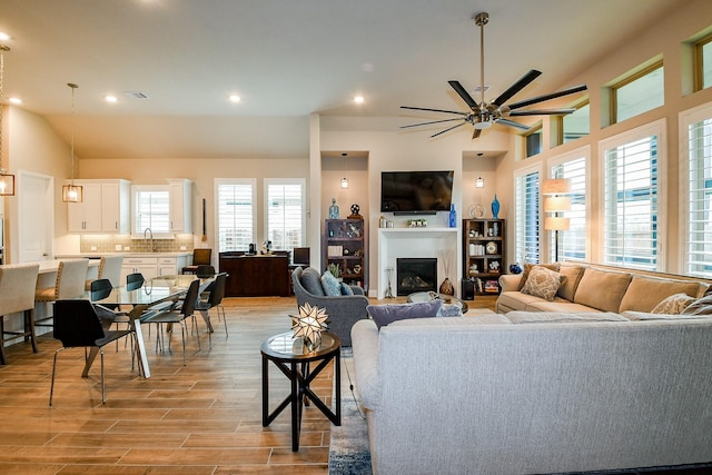 2234 Clements Shore Ln, La Porte, TX 77571 - living area featuring recessed lighting, a ceiling fan, light wood finished floors, lofted ceiling, and a glass covered fireplace