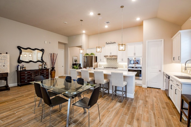2234 Clements Shore Ln, La Porte, TX 77571 - dining room featuring light wood-style floors, a high ceiling, and recessed lighting