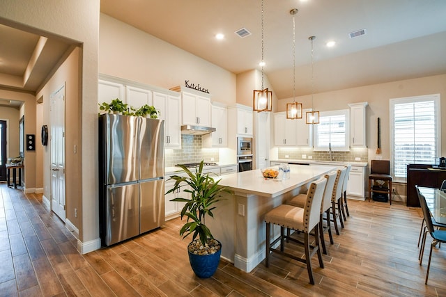 2234 Clements Shore Ln, La Porte, TX 77571 - kitchen featuring stainless steel appliances, a center island, light countertops, a kitchen breakfast bar, and a sink