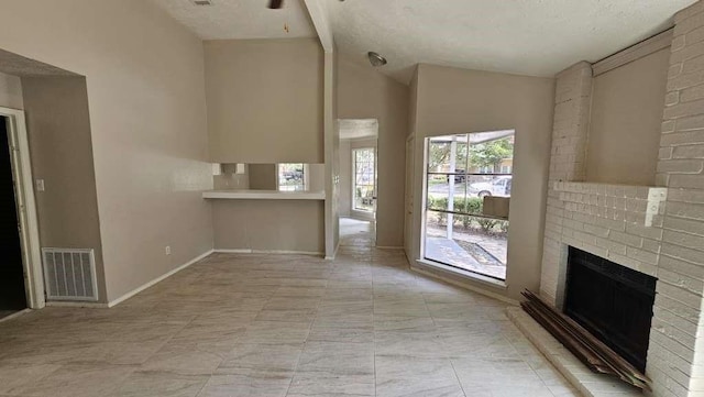 12107 Westwold Dr, Tomball, TX 77377 - unfurnished living room with a fireplace, lofted ceiling, baseboards, and a textured ceiling