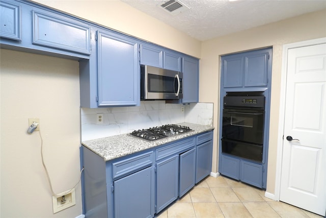 3911 Hermitage Hollow Ln, Houston, TX 77339 - kitchen featuring stainless steel appliances, blue cabinets, a warming drawer, and a textured ceiling