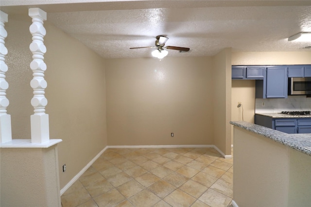 3911 Hermitage Hollow Ln, Houston, TX 77339 - kitchen featuring appliances with stainless steel finishes, a ceiling fan, a textured ceiling, blue cabinetry, and decorative backsplash