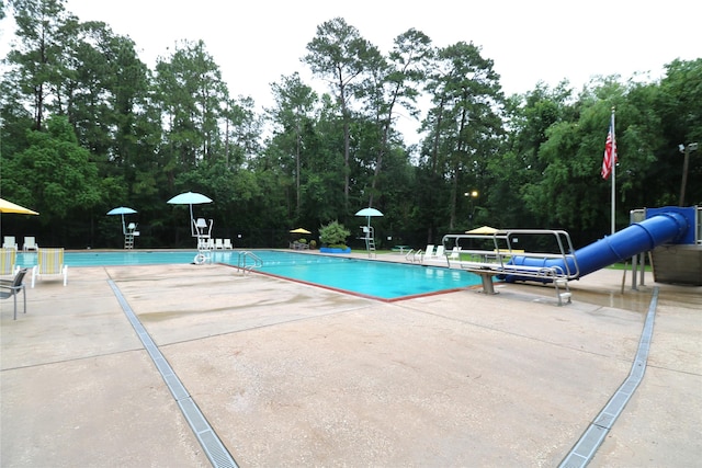 3911 Hermitage Hollow Ln, Houston, TX 77339 - community pool with a water slide, a patio, and view of scattered trees