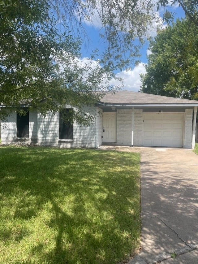 12811 Roandale Dr, Houston, TX 77048 - view of front facade with driveway, a front yard, brick siding, and a garage
