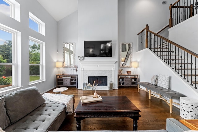 4807 Louisa Ct, Sugar Land, TX 77478 - living area featuring high vaulted ceiling, wood finished floors, stairs, a glass covered fireplace, and baseboards