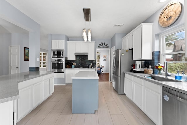 4807 Louisa Ct, Sugar Land, TX 77478 - kitchen with stainless steel appliances, a kitchen island, a sink, tasteful backsplash, and under cabinet range hood