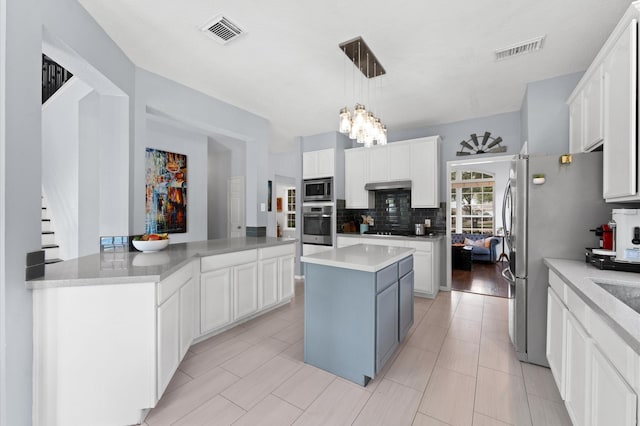 4807 Louisa Ct, Sugar Land, TX 77478 - kitchen featuring appliances with stainless steel finishes, a kitchen island, tasteful backsplash, a chandelier, and white cabinets