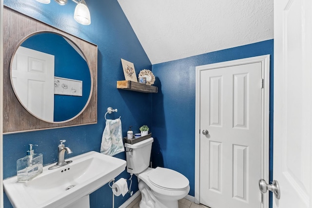 4807 Louisa Ct, Sugar Land, TX 77478 - bathroom with lofted ceiling, toilet, a sink, tile patterned flooring, and a textured wall
