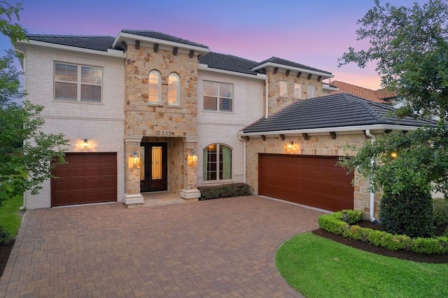 2319 Wyndam Heights Ln, Houston, TX 77077 - view of front of house with decorative driveway, a garage, stone siding, and a tile roof