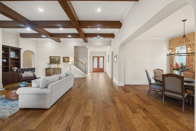 2319 Wyndam Heights Ln, Houston, TX 77077 - living room with arched walkways, a chandelier, beamed ceiling, stairway, and wood finished floors