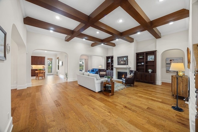 2319 Wyndam Heights Ln, Houston, TX 77077 - living room featuring arched walkways, coffered ceiling, light wood-style flooring, beam ceiling, and baseboards