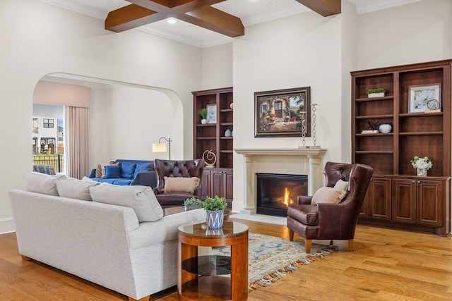 2319 Wyndam Heights Ln, Houston, TX 77077 - living room with arched walkways, light wood finished floors, a glass covered fireplace, beamed ceiling, and crown molding