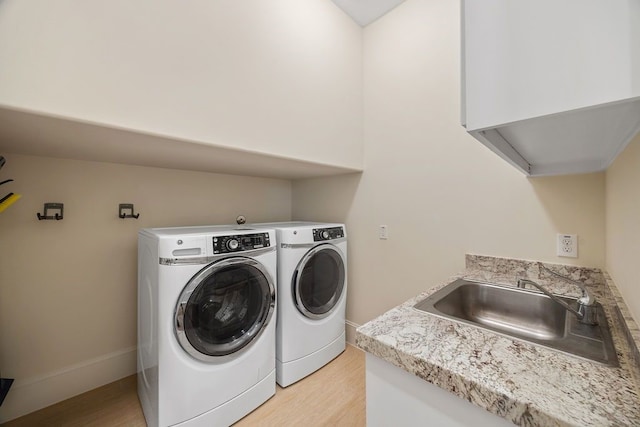 2319 Wyndam Heights Ln, Houston, TX 77077 - laundry room with washer and dryer, light wood-style flooring, and baseboards