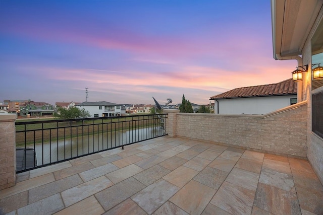2319 Wyndam Heights Ln, Houston, TX 77077 - patio terrace at dusk with a balcony, a residential view, and a water view