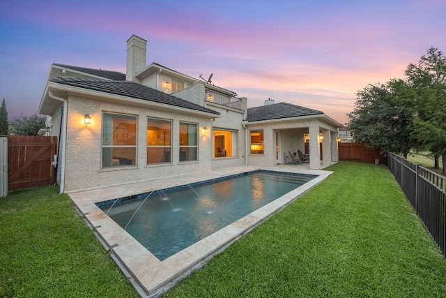 2319 Wyndam Heights Ln, Houston, TX 77077 - back of property at dusk featuring a balcony, a patio area, a tiled roof, and a chimney