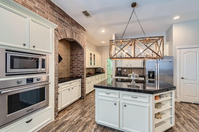 11519 Imperial Ln, Montgomery, TX 77316 - kitchen with stainless steel appliances, dark countertops, decorative backsplash, white cabinets, and a center island