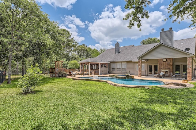 11519 Imperial Ln, Montgomery, TX 77316 - rear view of house featuring french doors, a patio area, a pool with connected hot tub, brick siding, and a chimney