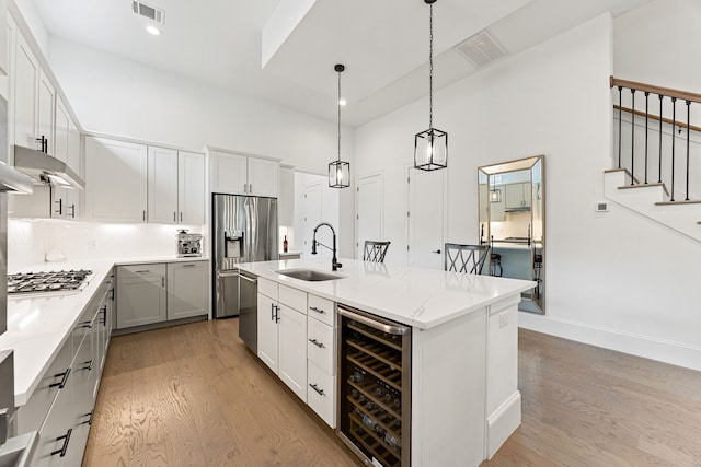 1433 Alexander St, Houston, TX 77008 - kitchen featuring wine cooler, a sink, light wood finished floors, appliances with stainless steel finishes, and recessed lighting