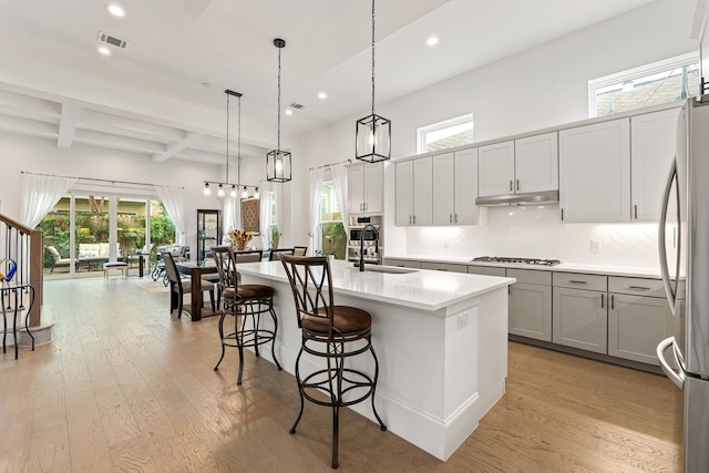 1433 Alexander St, Houston, TX 77008 - kitchen featuring stainless steel appliances, light wood-style floors, recessed lighting, plenty of natural light, and beamed ceiling