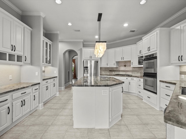 2905 Sea Channel Dr, Seabrook, TX 77586 - kitchen featuring appliances with stainless steel finishes, arched walkways, recessed lighting, backsplash, and a chandelier