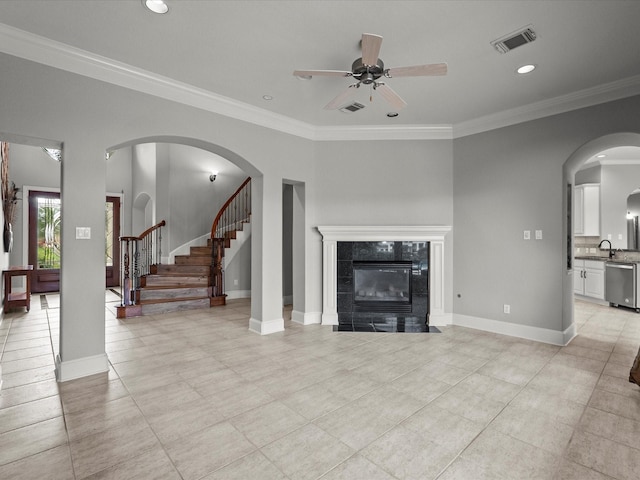 2905 Sea Channel Dr, Seabrook, TX 77586 - unfurnished living room with a ceiling fan, a tiled fireplace, a sink, crown molding, and baseboards