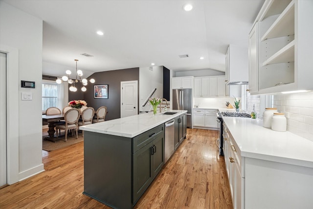 2218 Gardenia Dr, Houston, TX 77018 - kitchen with stainless steel appliances, white cabinets, a sink, a chandelier, and light wood finished floors