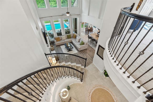 399 Black Walnut Dr, Conroe, TX 77304 - stairs featuring a towering ceiling, tile patterned floors, and a ceiling fan