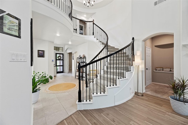 399 Black Walnut Dr, Conroe, TX 77304 - entrance foyer featuring arched walkways, a high ceiling, stairs, wood finished floors, and baseboards