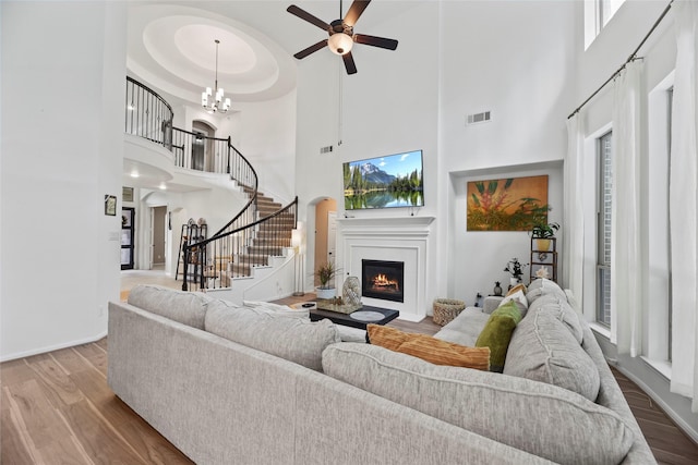 399 Black Walnut Dr, Conroe, TX 77304 - living room with wood finished floors, a high ceiling, a lit fireplace, stairs, and a ceiling fan