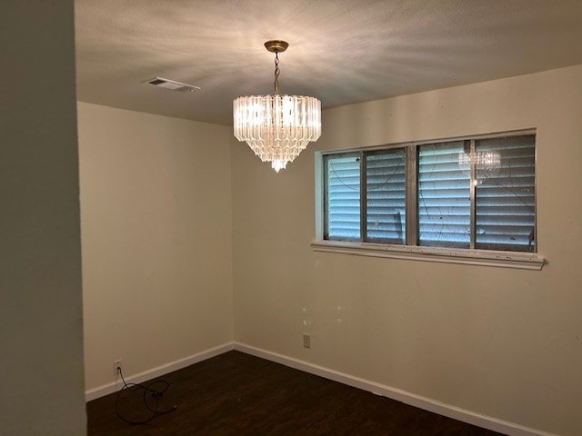 6619 Carver Ave, Hitchcock, TX 77563 - spare room with wood finished floors, a chandelier, and baseboards