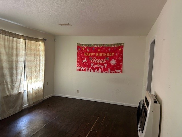 6619 Carver Ave, Hitchcock, TX 77563 - empty room featuring heating unit, wood finished floors, a textured ceiling, and baseboards