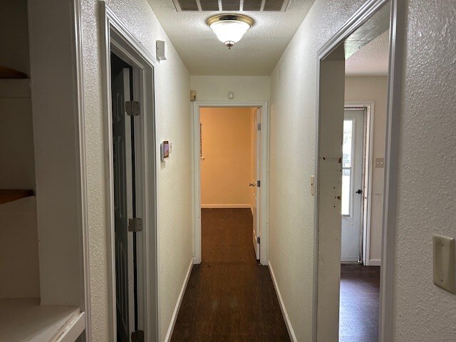 6619 Carver Ave, Hitchcock, TX 77563 - hall with a textured wall, wood finished floors, and baseboards