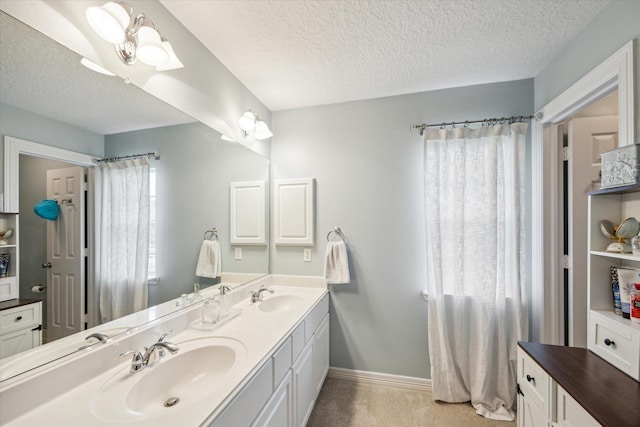 19 Remington Park, Katy, TX 77493 - full bathroom featuring a textured ceiling, double vanity, and baseboards