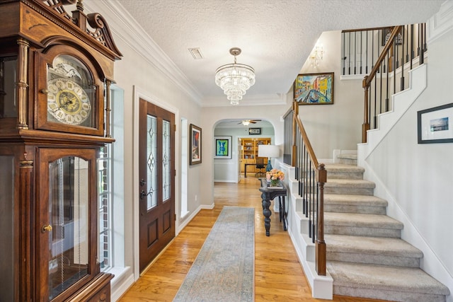 19 Remington Park, Katy, TX 77493 - entrance foyer featuring stairs, arched walkways, light wood-style flooring, a chandelier, and ornamental molding