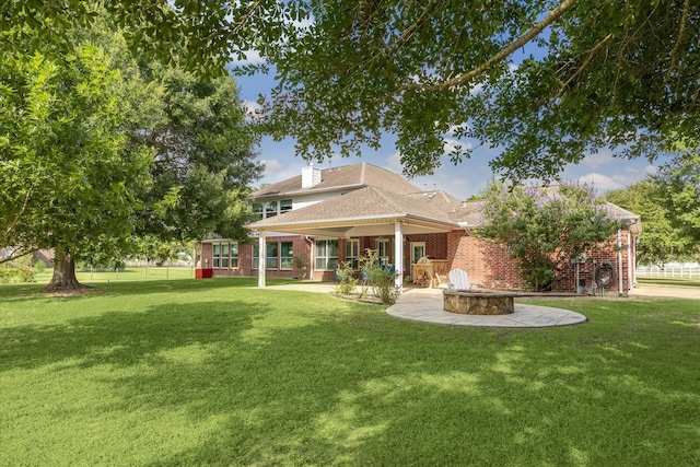 19 Remington Park, Katy, TX 77493 - rear view of property with brick siding, a lawn, and a fire pit