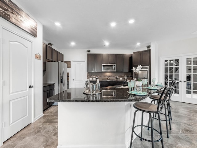 14306 Cedar Pine Ct, Houston, TX 77068 - kitchen with stainless steel appliances, french doors, dark brown cabinets, a breakfast bar area, and a sink