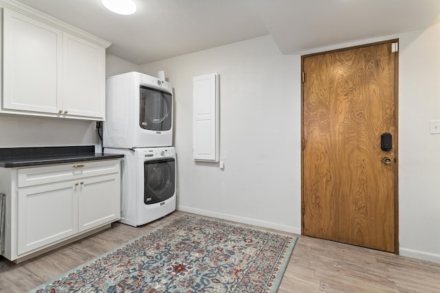 1240 Oakcrest Cir, Beaumont, TX 77706 - laundry area featuring estacked washer and dryer, cabinet space, baseboards, and light wood-type flooring