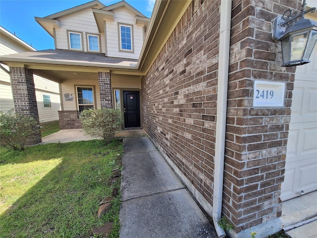 2419 Fort Baldy Trl, Humble, TX 77396 - doorway to property featuring brick siding, a garage, a yard, and covered porch