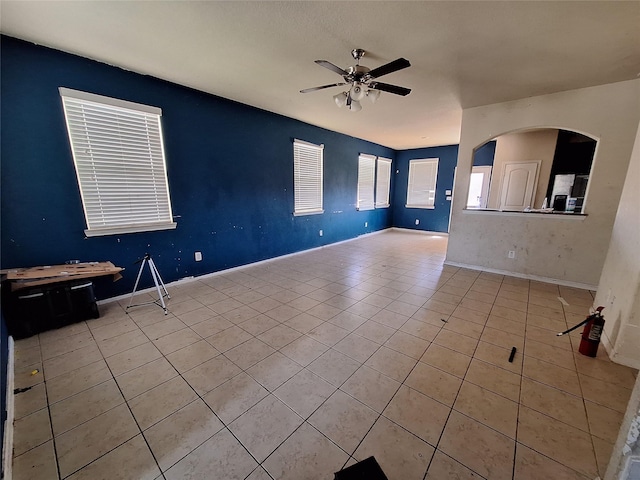 2419 Fort Baldy Trl, Humble, TX 77396 - unfurnished room with a ceiling fan, light tile patterned floors, baseboards, and arched walkways