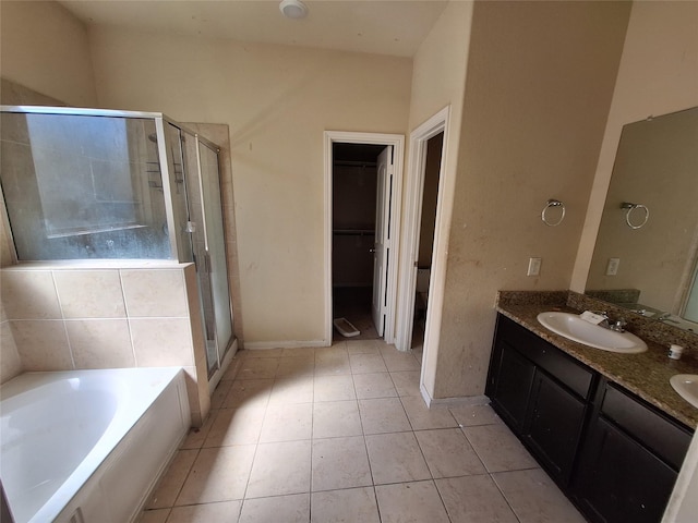 2419 Fort Baldy Trl, Humble, TX 77396 - full bath featuring a shower stall, double vanity, a bath, tile patterned flooring, and a walk in closet