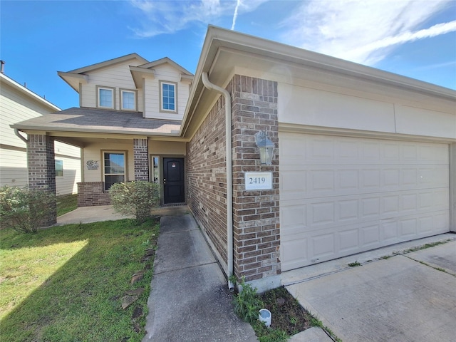 2419 Fort Baldy Trl, Humble, TX 77396 - view of front of home with brick siding, a garage, driveway, and a front lawn