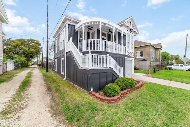 1611 19th St, Galveston, TX 77550 - view of front of house featuring driveway, a front lawn, a ceiling fan, stairs, and an attached garage